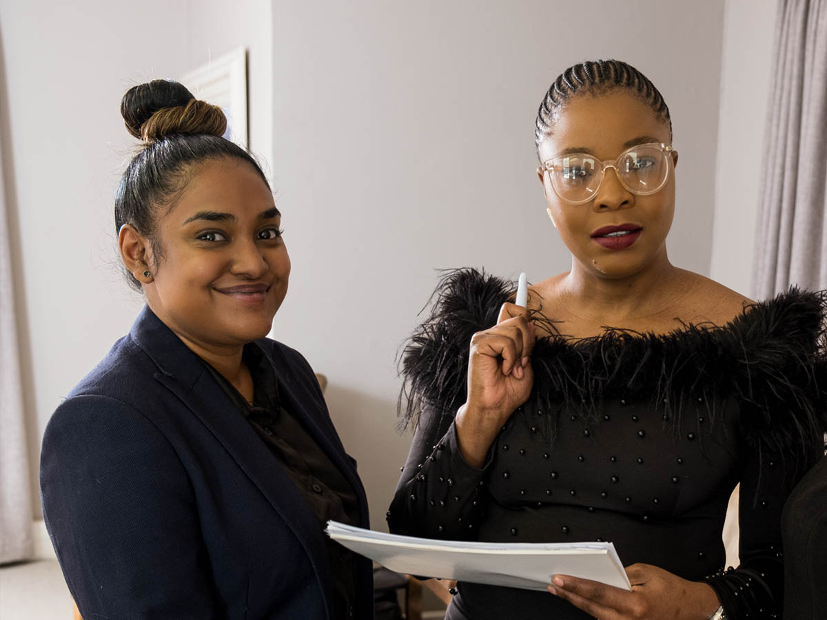 Two recruitment consultants reviewing candidate documents in a South African office